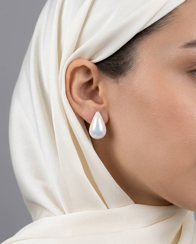 گوشواره میخی طرح اشک با تلألؤ هفترنگ صدفی روی گوش